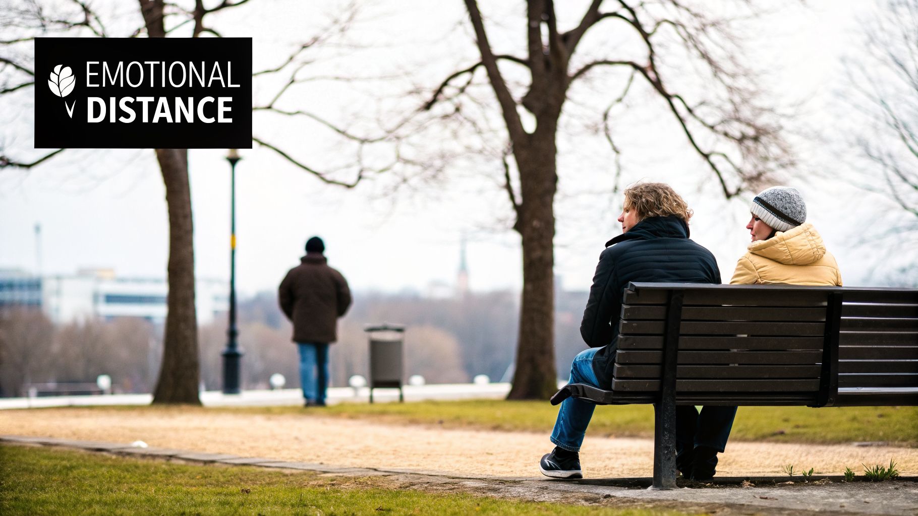 Two people on a park bench facing away, depicting emotional distance, with a person walking away in the background.