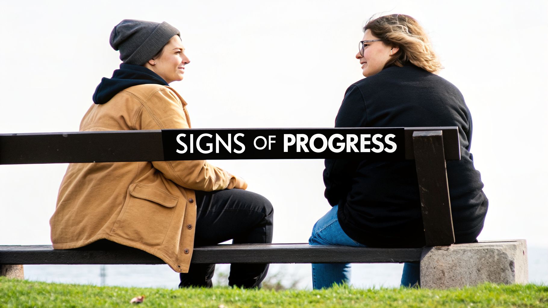 Two people sitting on a park bench, facing each other and talking, with "SIGNS OF PROGRESS" overlaid.