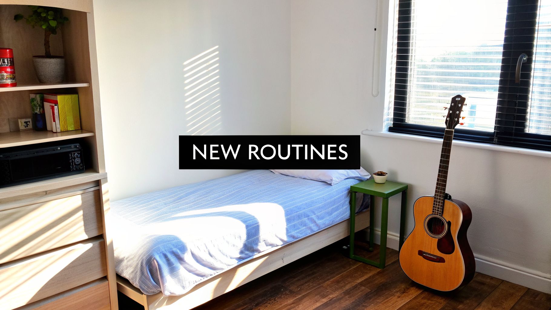 A simple sunlit bedroom with a bed, shelving unit, and an acoustic guitar by the window.