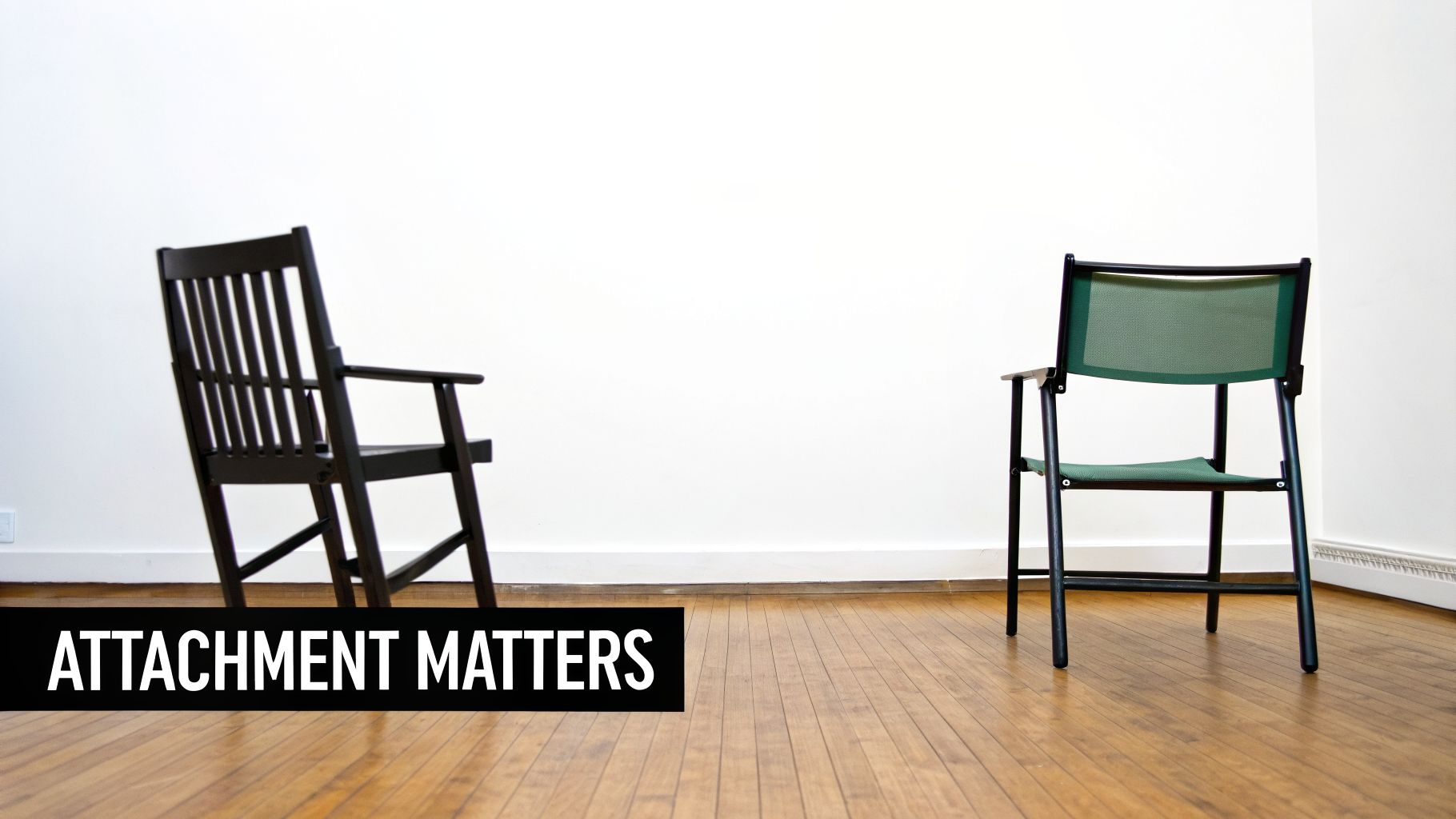 Two chairs, one wooden and one green mesh, face away from each other in an empty room.