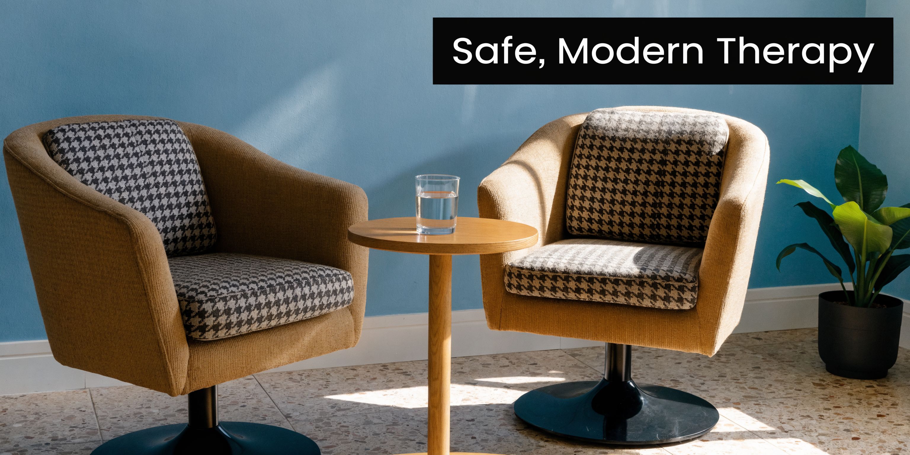 Two comfortable armchairs with houndstooth patterned cushions face each other with a small table in between.