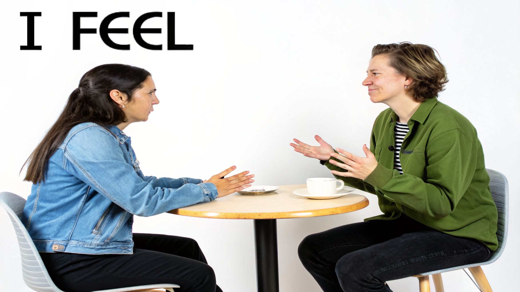Two women sit at a table, gesturing hands while conversing, with 'I FEEL' text above.