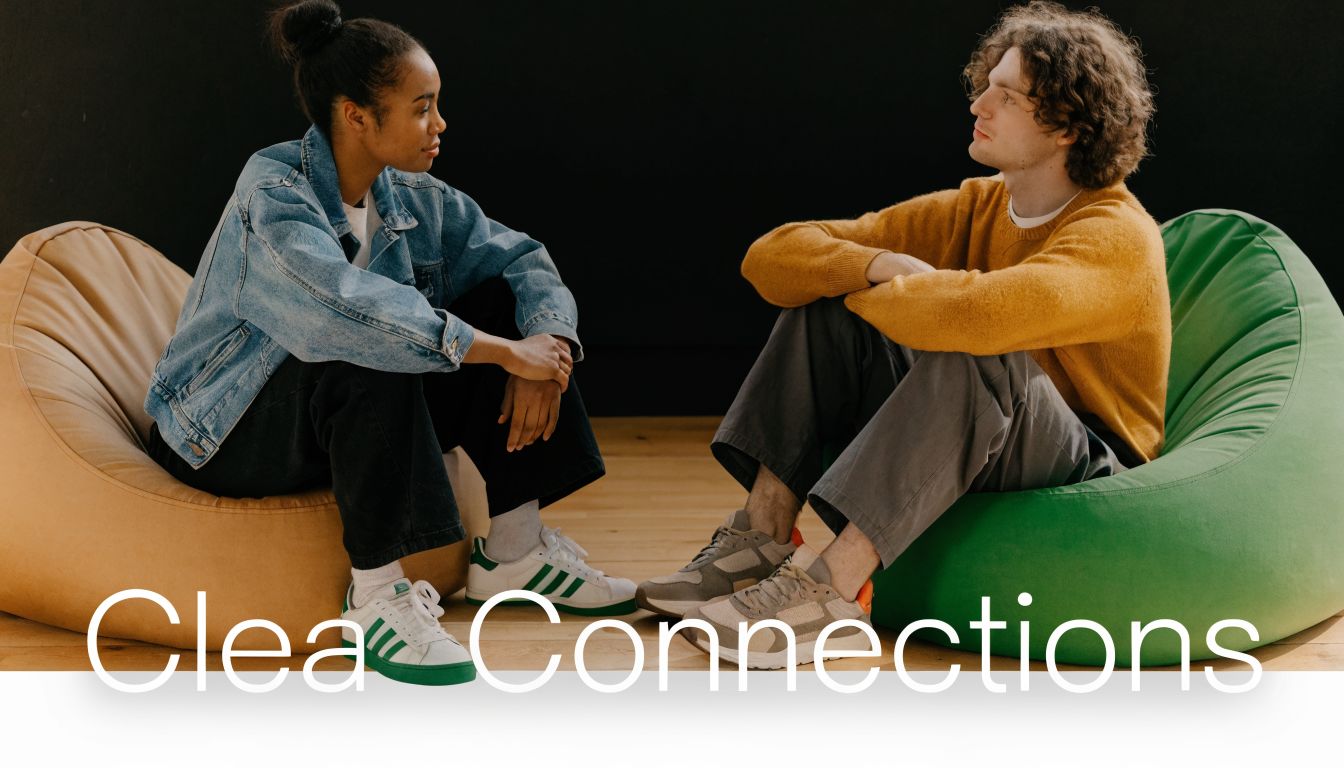 A woman and a man sitting on bean bag chairs across from each other having a conversation.