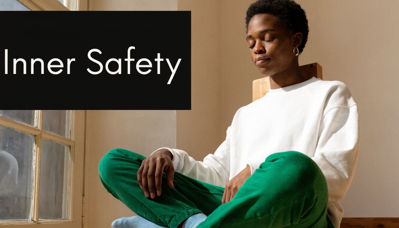 A person sitting peacefully in meditation with their eyes closed, wearing a white sweater and green trousers.