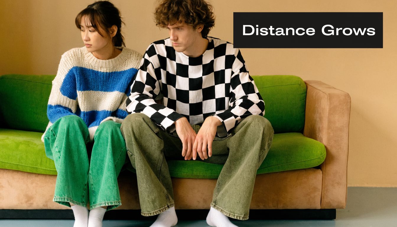 A young couple sits apart on a green sofa, looking away from each other with somber expressions.