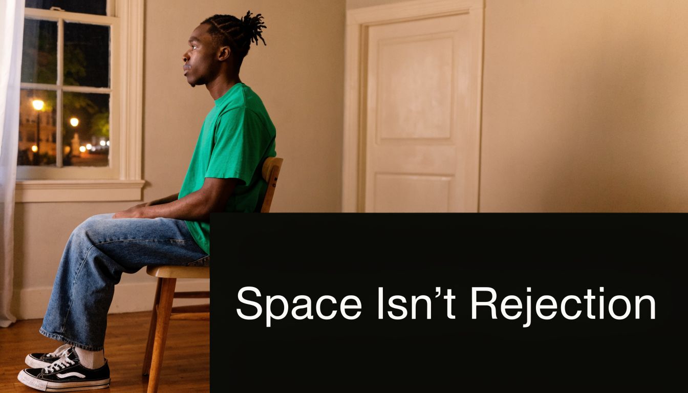 A young Black man sitting on a chair by a window, contemplating in a quiet room.