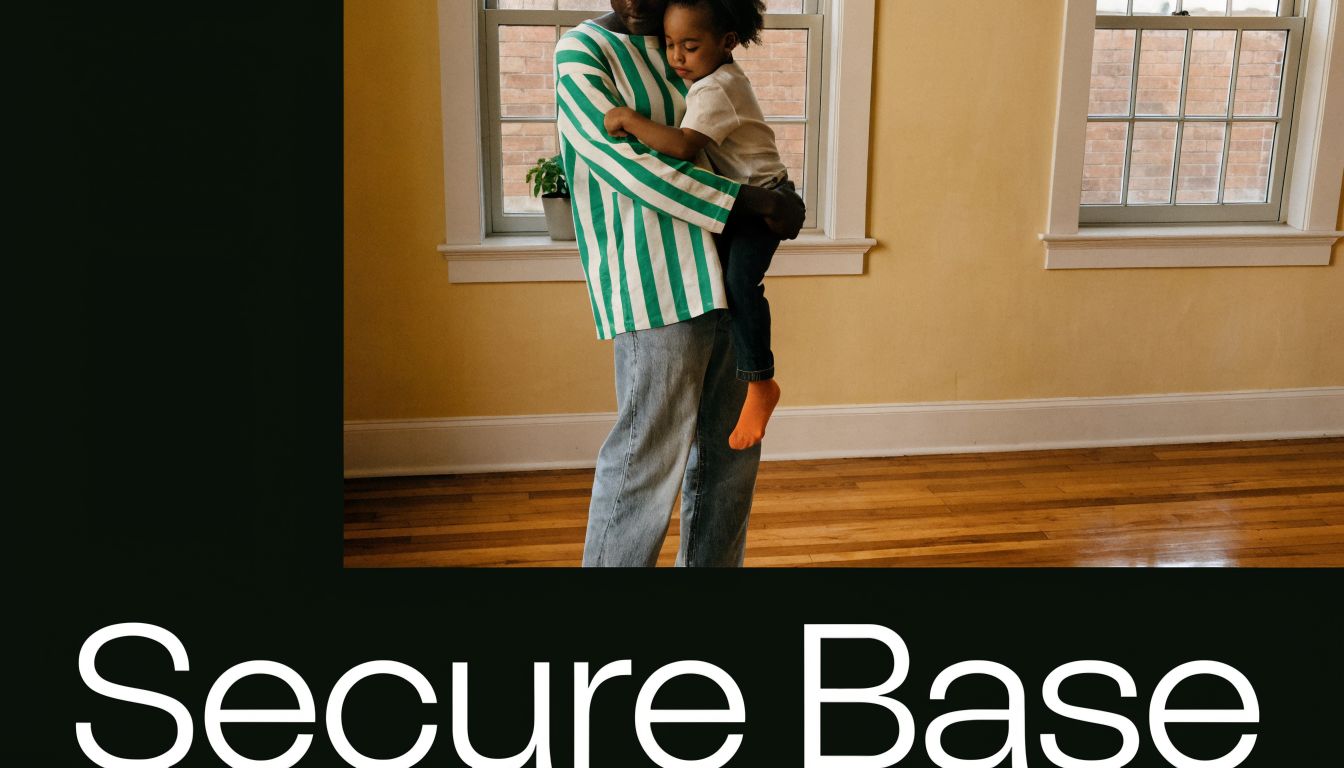 An adult holding a young child securely in a bright room with yellow walls and wooden floors.